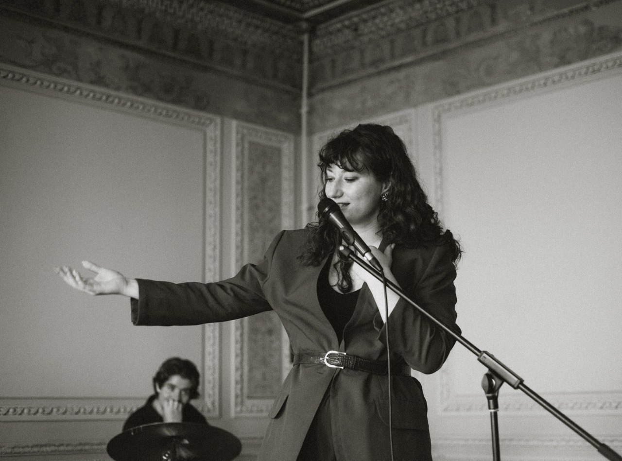 Yana Litinskaya performing live at the microphone during a masterclass session